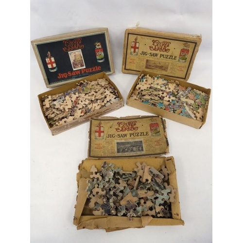 244 - Three boxes of wooden jigsaw puzzles and a lace tray cloth