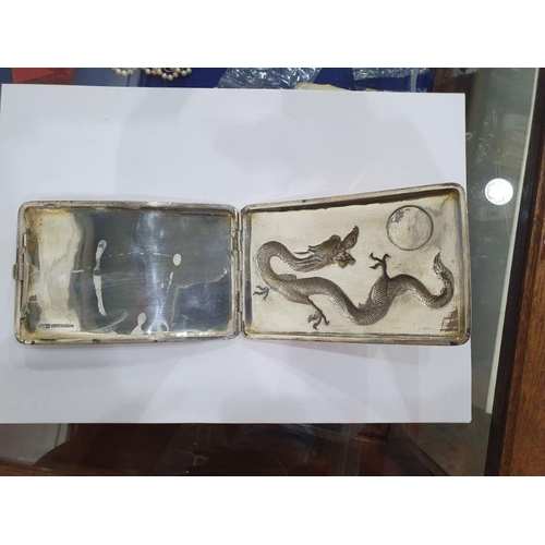 454 - Chinese silver cigarette case, rectangular and curved, the hinged lid repousse with dragon chasing p... 