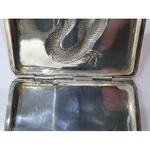 454 - Chinese silver cigarette case, rectangular and curved, the hinged lid repousse with dragon chasing p... 