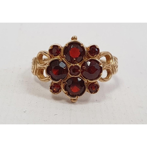 565 - 9ct gold lady's ring with four large and five small garnets, in flowerhead setting, 4.5g