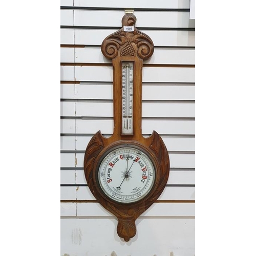 1003 - Oak aneroid barometer with scroll pediment, the enamel dial with thermometer, 82cm long overall