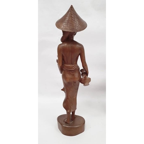 181 - Assorted 20th century Eastern carved figures to include figure in hat carrying jug and basket, anoth... 