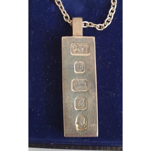 277 - Silver ingot pendant on chain, a white metal box of oval form with hinged cover decorated with a lio... 