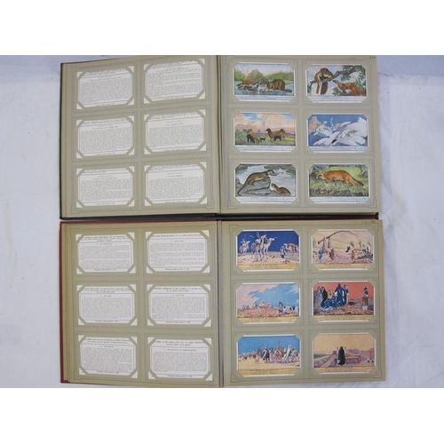 216 - Two albums of trade cards 'Chromos Liebig Chromo's' including 'De Koppoortigen', 'De Kalevala', 'De ... 