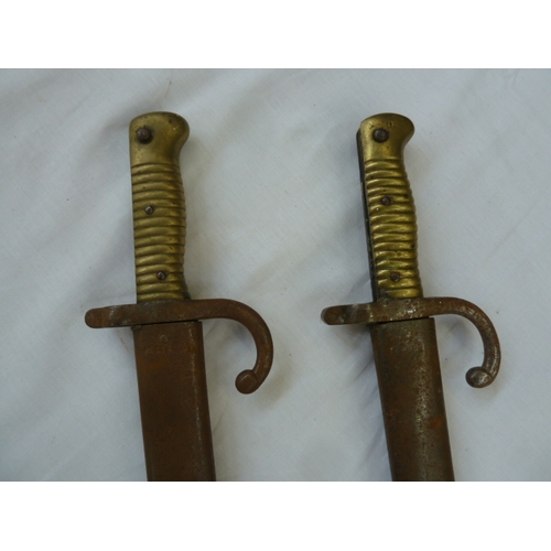 400A - Two 19th century French bayonets with scabbards (rusty)