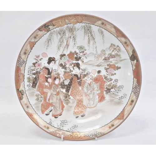 123 - Japanese Kutani porcelain shallow dish, circular and decorated with figures beside a lake in iron re... 