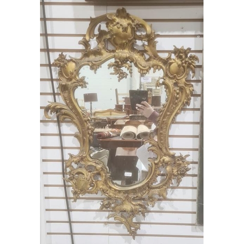 1420 - Possibly 19th century mirror, the shaped plate in gilt bronze rococo-style frame, 82cm x 49cm approx