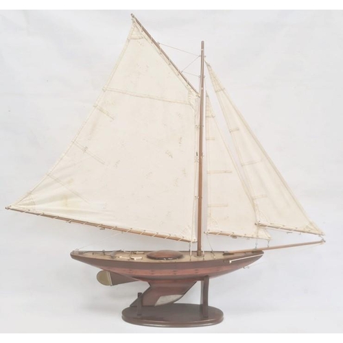 152 - Varnished wood model yacht with canvas sails and metal fittings and the associated wooden stand, 91c... 