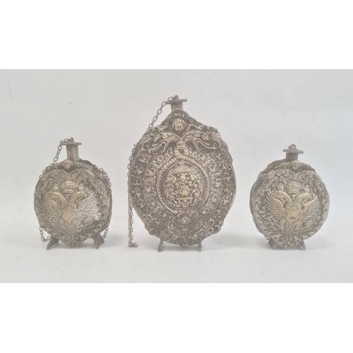 211 - Three silver coloured metal gunpowder flasks, possibly Russian, all relief decorated, two depicting ... 