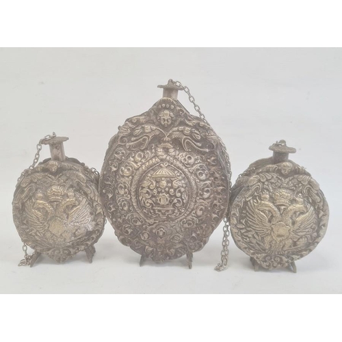 211 - Three silver coloured metal gunpowder flasks, possibly Russian, all relief decorated, two depicting ... 