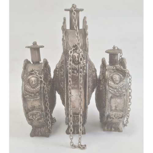 211 - Three silver coloured metal gunpowder flasks, possibly Russian, all relief decorated, two depicting ... 