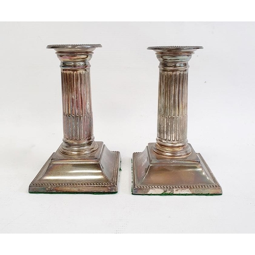 405 - Pair of late 19th/early 20th century silver-mounted candlestick holders with beaded rims to fluted c... 