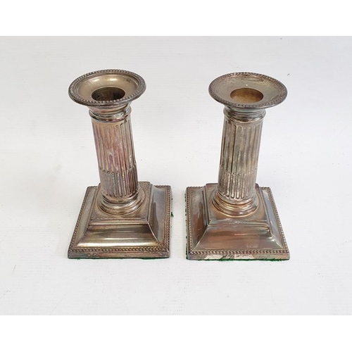 405 - Pair of late 19th/early 20th century silver-mounted candlestick holders with beaded rims to fluted c... 