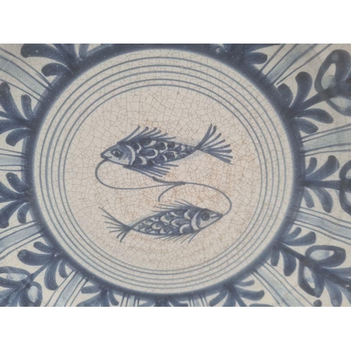 18 - Four modern Spanish blue and white dishes decorated with birds, fish and flowers, within stylised bo... 