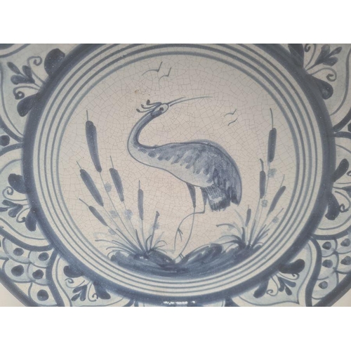 18 - Four modern Spanish blue and white dishes decorated with birds, fish and flowers, within stylised bo... 