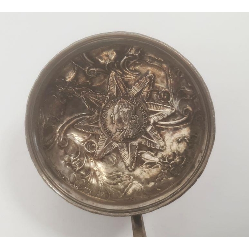 357 - Silver-coloured mounted ladle inset with George II coin and repousse decorated, with turned handle