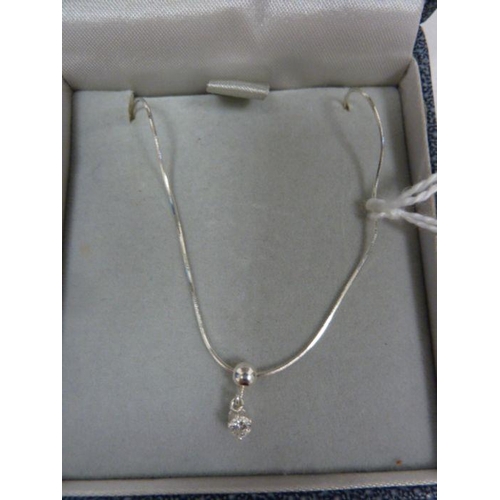 410 - Solitaire diamond drop pendant, claw-set in silver mount, on fine chain, the stone approx 0.10ct