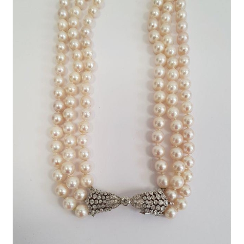 469 - Diamond and pearl triple strand necklace having diamond set bow-shaped clasp with collet set stone a... 