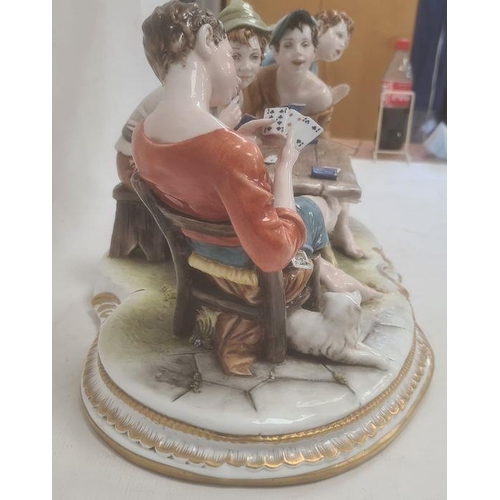 48 - Ciche porcelain figural group of boys seated at a table playing cards, the oval base with gilt borde... 