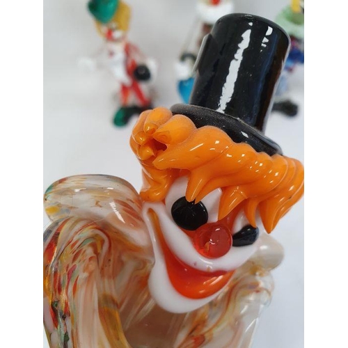 72 - Murano glass clown holding a blue umbrella, 29cm high, another holding a marbled ball and four other... 