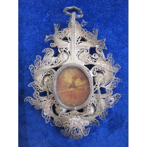 71 - Victorian silver filigree Reliquary pendant with central oval glass enclosing writing on paper inscr... 