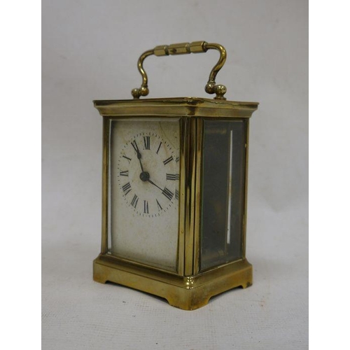 1063 - Brass and glass-cased carriage clock with handle