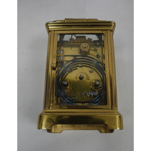 1085 - Brass and glass carriage clock with Roman numerals to the dial, in leather carry case