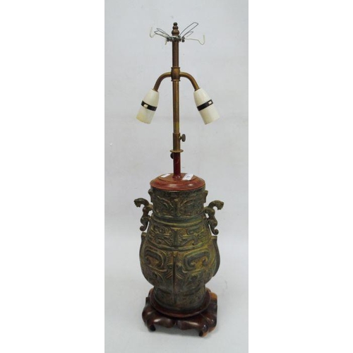 118 - Cast bronze baluster vase-patterned table lamp, two-handled and on carved hardwood scroll base, fitt... 