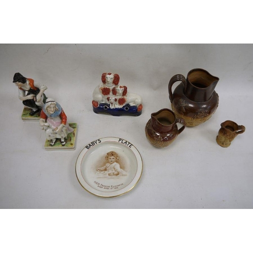 17 - Three stoneware jugs, Staffordshire flatware spaniel group, pair of figures and a baby plate 'HRH Pr... 