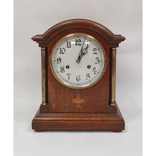 1067 - Oak-cased mantel clock with arched top, Arabic numerals to the dial, on plinth base