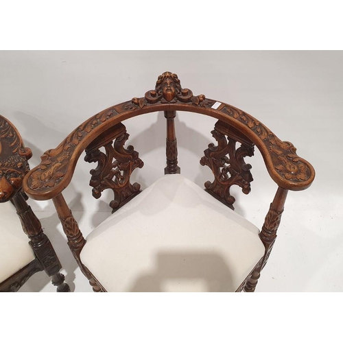 1352 - Two similar corner armchairs with heavily carved top rails featuring mask decoration, carved and pie... 