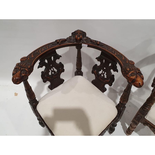 1352 - Two similar corner armchairs with heavily carved top rails featuring mask decoration, carved and pie... 