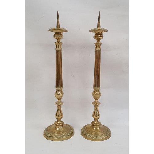 100 - Pair of brass pricket candlesticks with fluted and knopped stems, on circular bases, 56cm high (2)