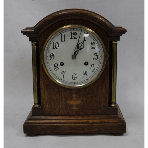 1067 - Oak-cased mantel clock with arched top, Arabic numerals to the dial, on plinth base