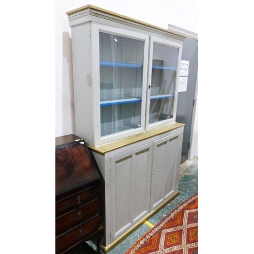 1114A - Painted cabinet with moulded corners above two glazed doors enclosing shelves, the painted base of t... 