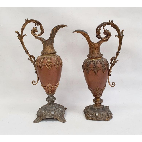 121 - Pair of ornate metal ewers, the copper bodies with gilded mounts, with scroll handles, on circular b... 