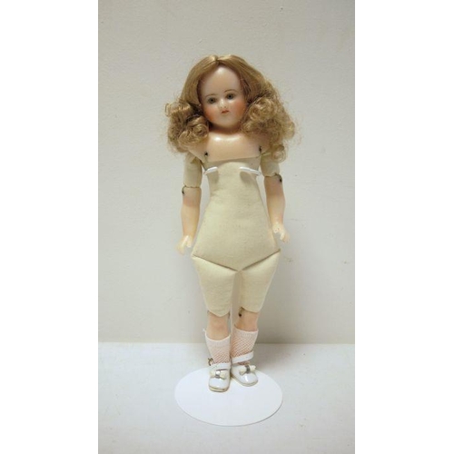 267 - Waxed shoulderhead doll with inset green glass eyes, soft body with waxed lower limbs, 42cm high