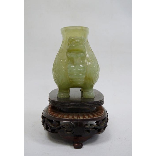 90 - Chinese jade censer, dog of Fo mask handles, and raised on four feet, together with a carved wood fi... 