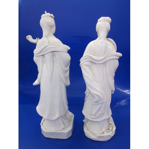 133 - Two blanc de chine porcelain figures of courtesans, one with a fan and the other with stringed instr... 