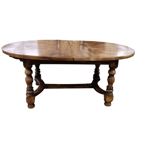 21 - Stained elm extending dining table of revived 17th century-style, the oval top with extra leaf and o... 