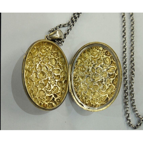 385 - Silver gilt-coloured metal locket on long silver-coloured metal chain