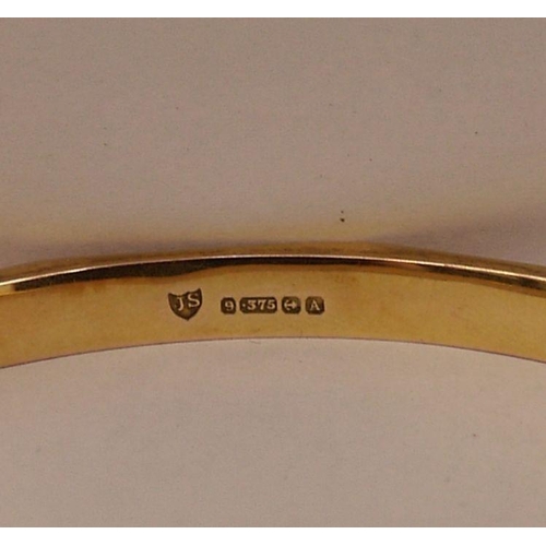 409 - 9ct gold slave bangle panelled with key-pattern engraving, 16.2g