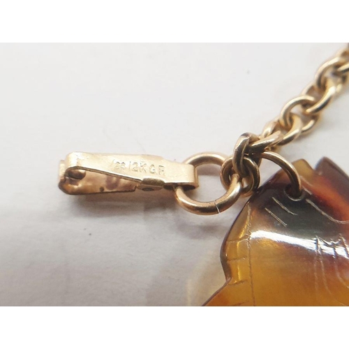 549 - Gold belcher-link bracelet marked 12K and hung with seven assorted tortoiseshell charms including a ... 