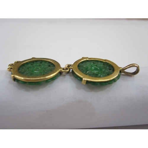 557 - Gold bar brooch set with oval jade plaque, marked 15ct, a gold-coloured pendant set with two pierced... 