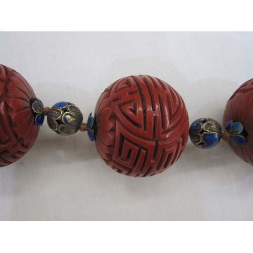 363 - Oriental cinnabar and enamel shou necklace, the large cinnabar beads carved geometric design and flo... 