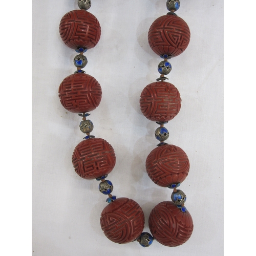 363 - Oriental cinnabar and enamel shou necklace, the large cinnabar beads carved geometric design and flo... 