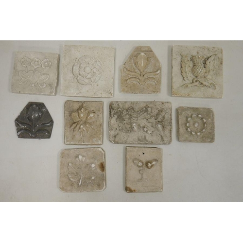 27 - Collection of plaster tiles, each moulded with flowers, leaves/acorns, including a Tudor-style rose,... 