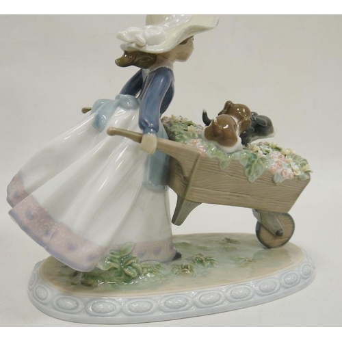 64 - Two Lladro figures, printed impress marks, the first modelled as a girl pushing a wheelbarrow with t... 