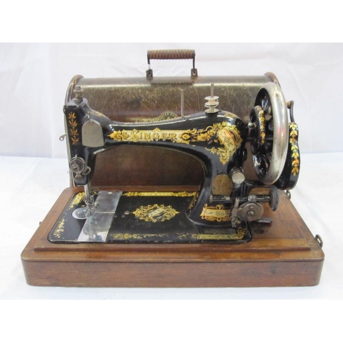 256 - Singer sewing machine in wooden dome box with contemporary user manuals and extra parts including fe... 