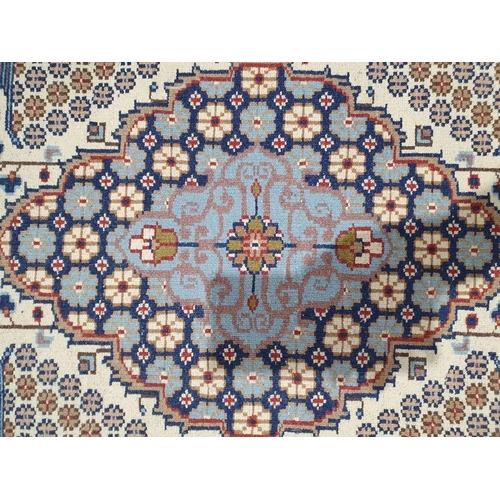 1018 - Persian style ivory rug with central lozenge medallions surrounded by floral and stylised animal des... 